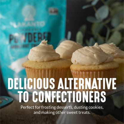 Close-up of cupcakes with light frosting on a stand. A blue bag, labeled Powdered Monkfruit and Erythritol Sweetener by Lakanto, appears in the background. Text reads: A zero-calorie confectioners alternative for frosting, dusting cookies, or sweet treats. Perfect for keto-friendly recipes!.